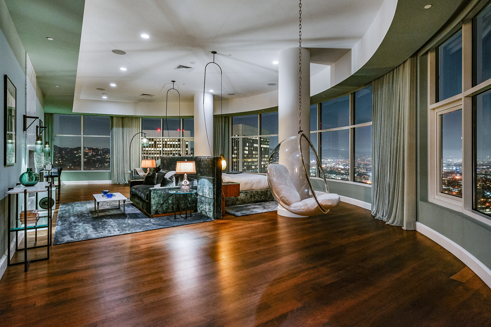 Dark hardwood flooring throughout the entire Malibu condo, with a circular chair hanging from the ceiling
