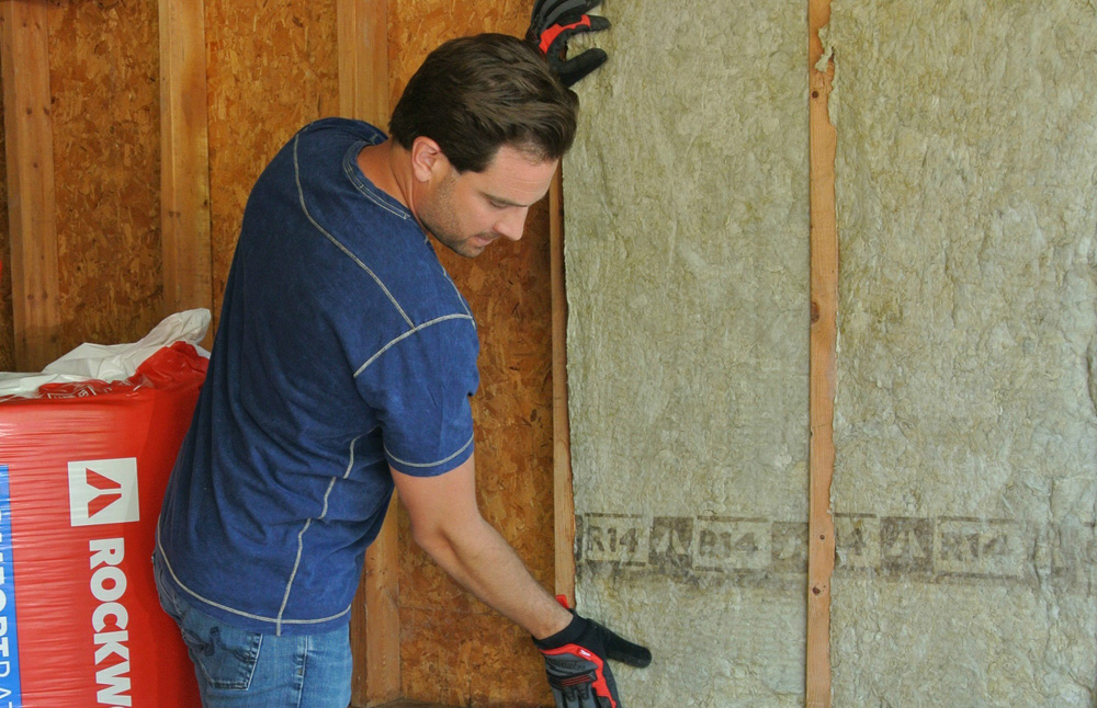 Scott McGillivray installs insulation during a renovation