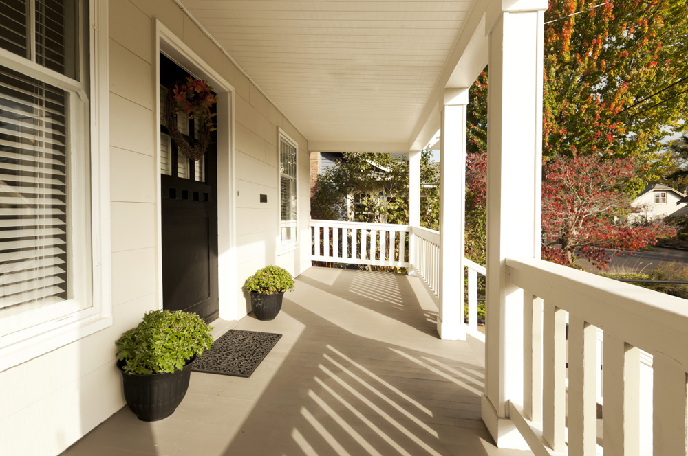 A wraparound front porch with welcome mat