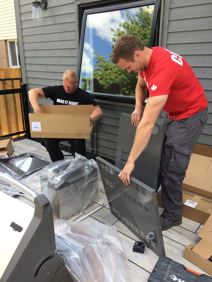 Mike Holmes and Mike Holmes Jr unpacking a new barbecue