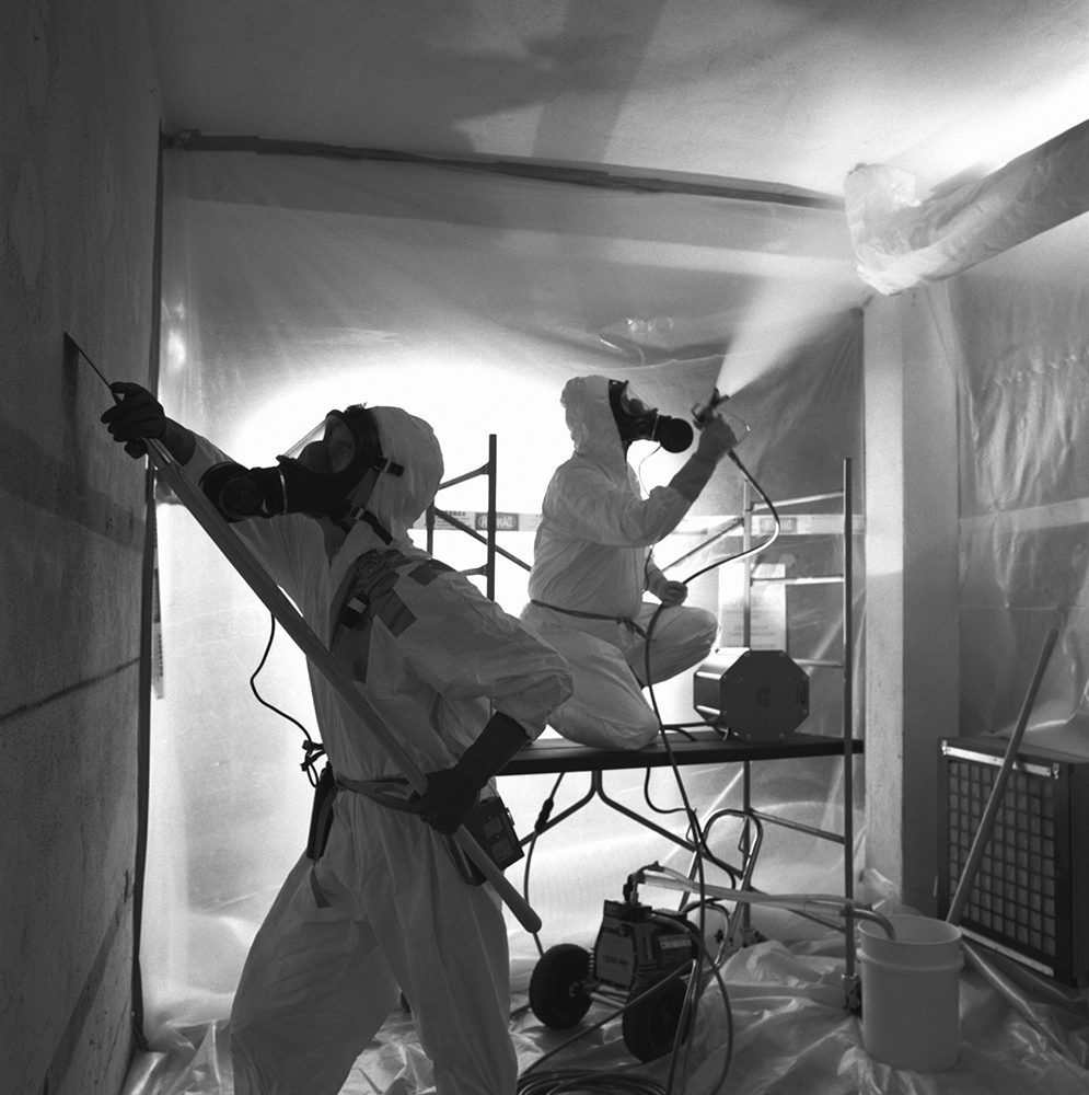 People in protective suits removing asbestos
