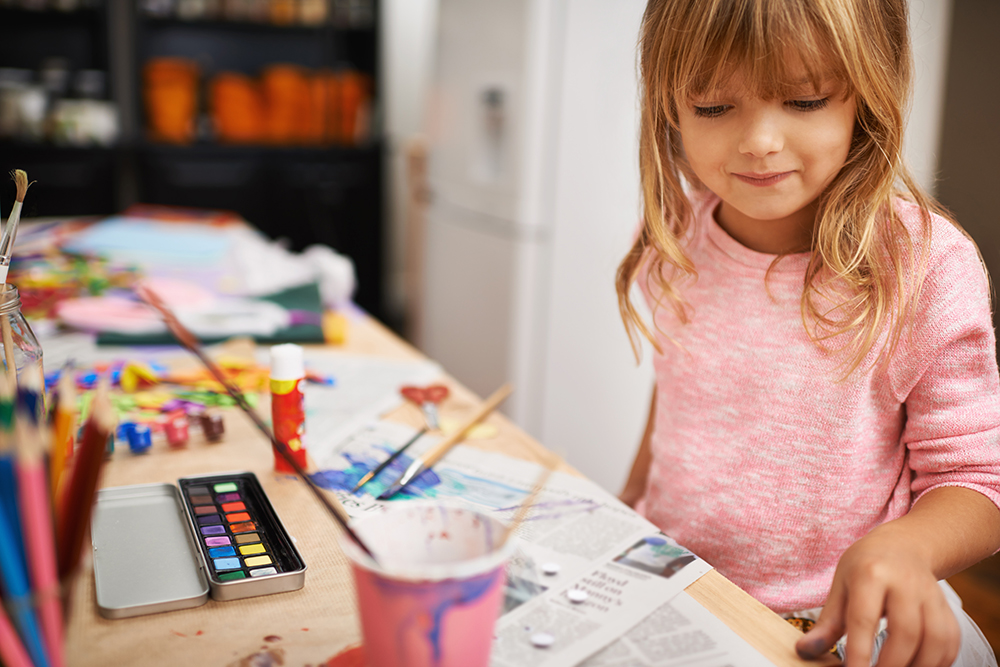 Little girl at a painting and crafts table
