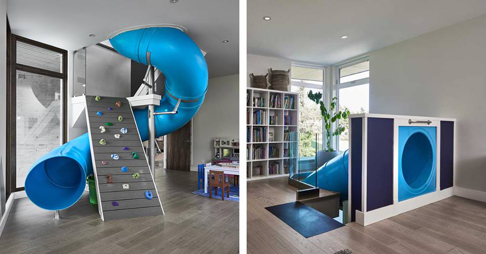 A blue indoor slide and rock climbing wall