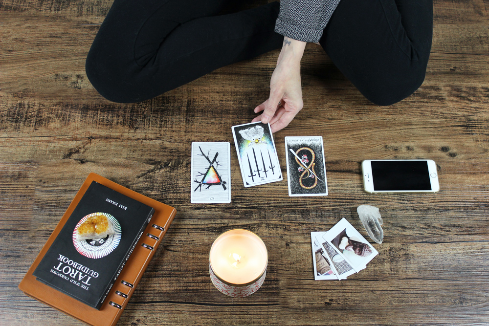 A woman lays down cards from her tarot deck
