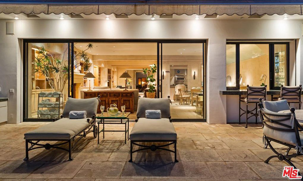 Backyard patio space with floor-to-ceiling sliding doors that lead into the open-concept living room and dining room