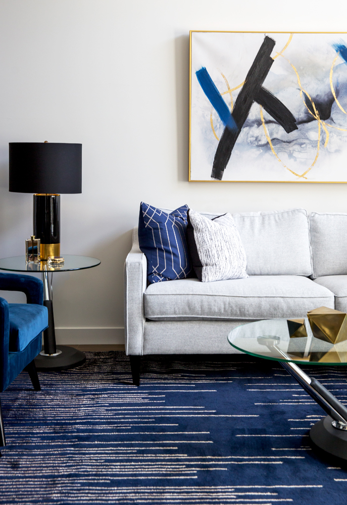 Living room with blue chairs and white sofa with a black and gold lamp