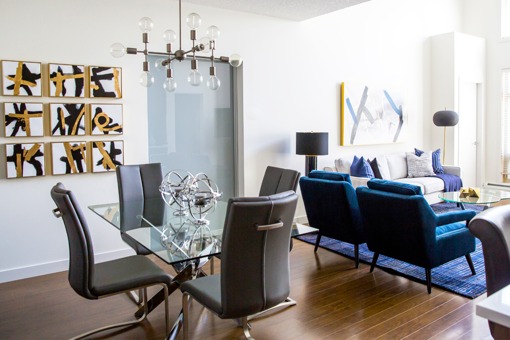 Condo with glass dining table and blue velvet chairs