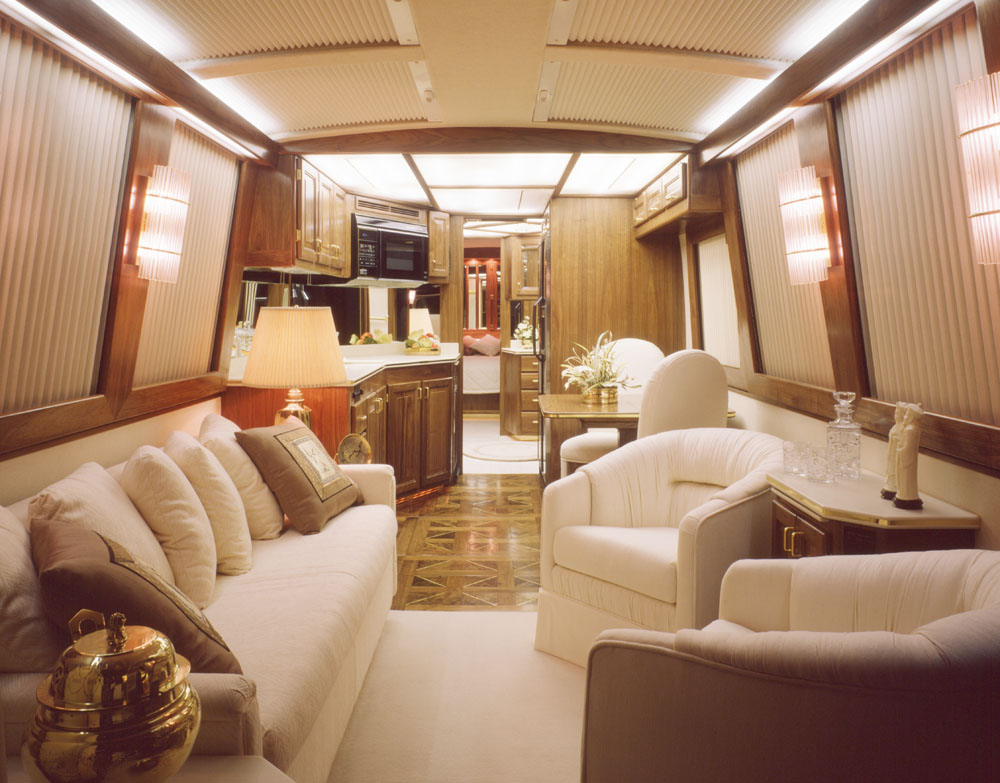 The interior of a luxury mobile home featuring neutral tones and plenty of comfy furniture