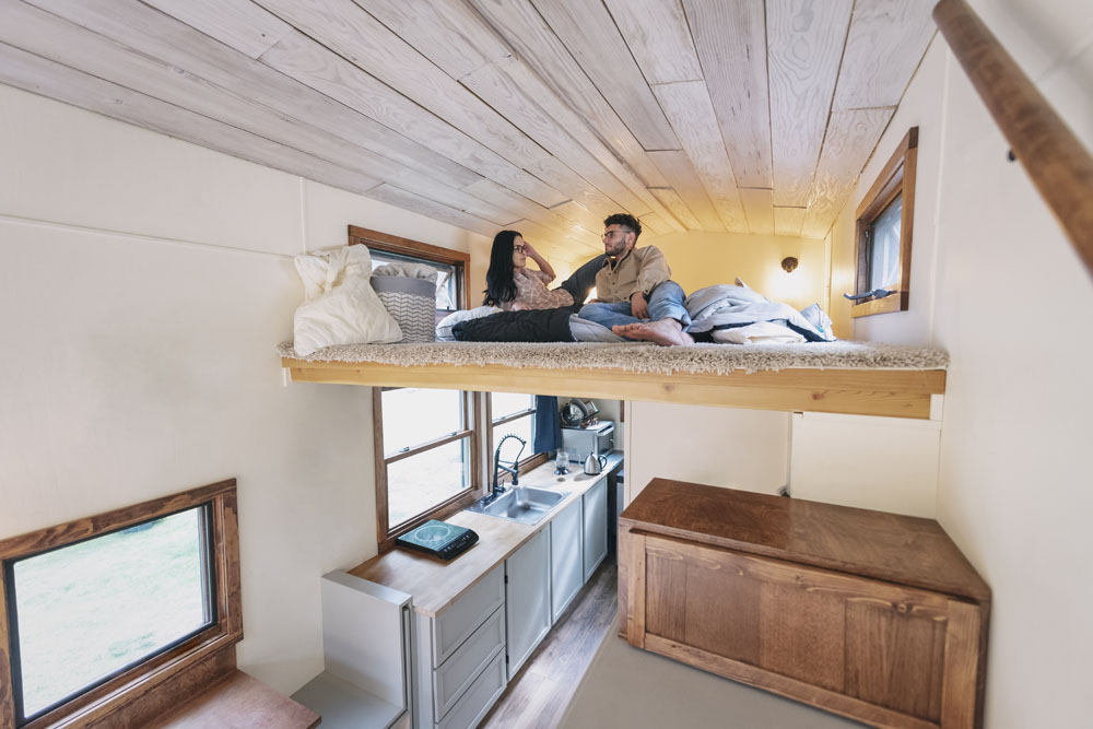 A couple in an elevated bed in their mobile home
