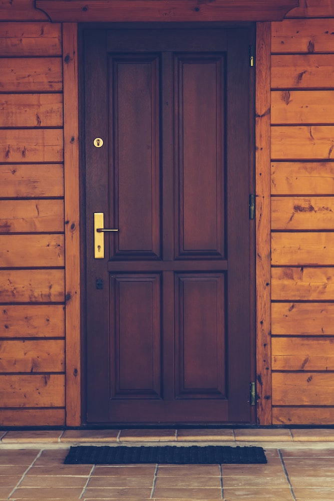 brown front door with shiny metallic handle