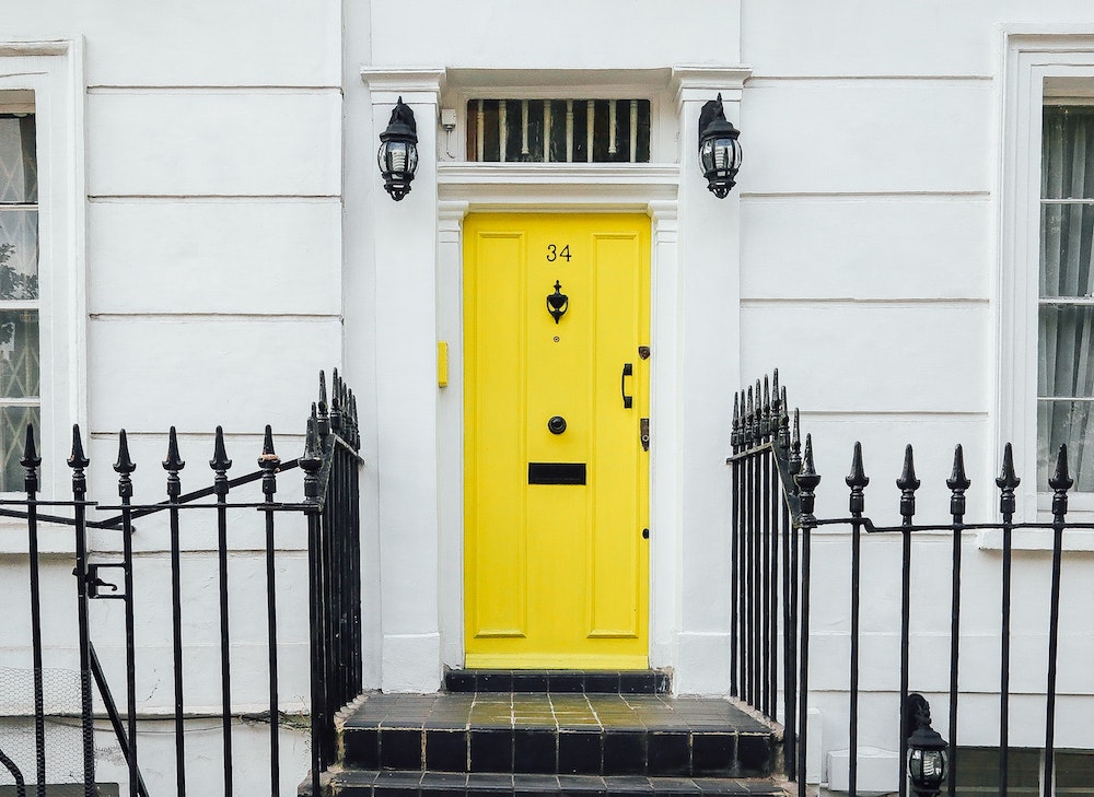white home exterior with yellow front door