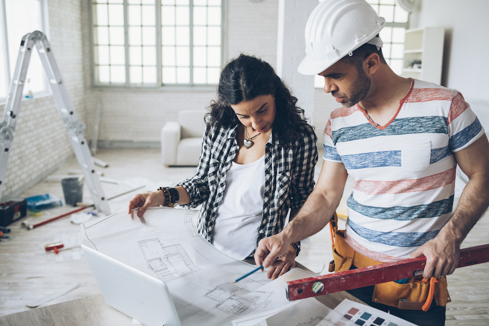 woman and construction worker looking at blueprints