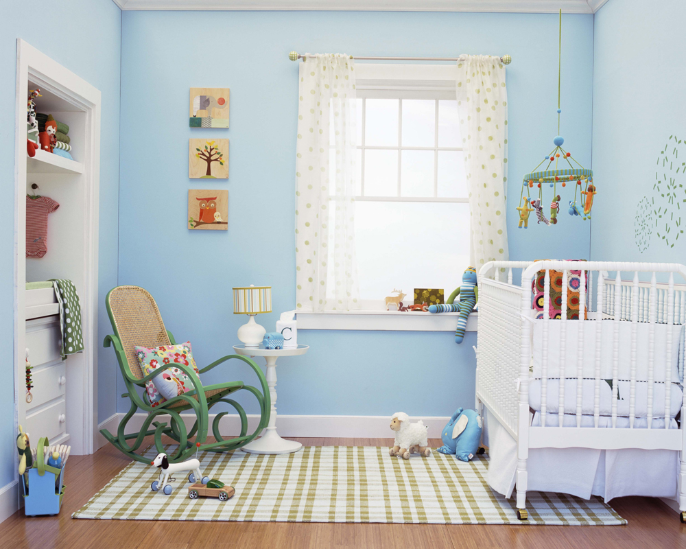 A gender-neutral pastel blue nursery filled with little trinkets, toys and decor pieces