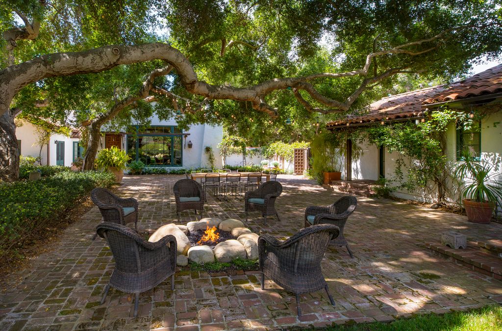 A central courtyard with trees for shade, a fire pit and al fresco dining setup