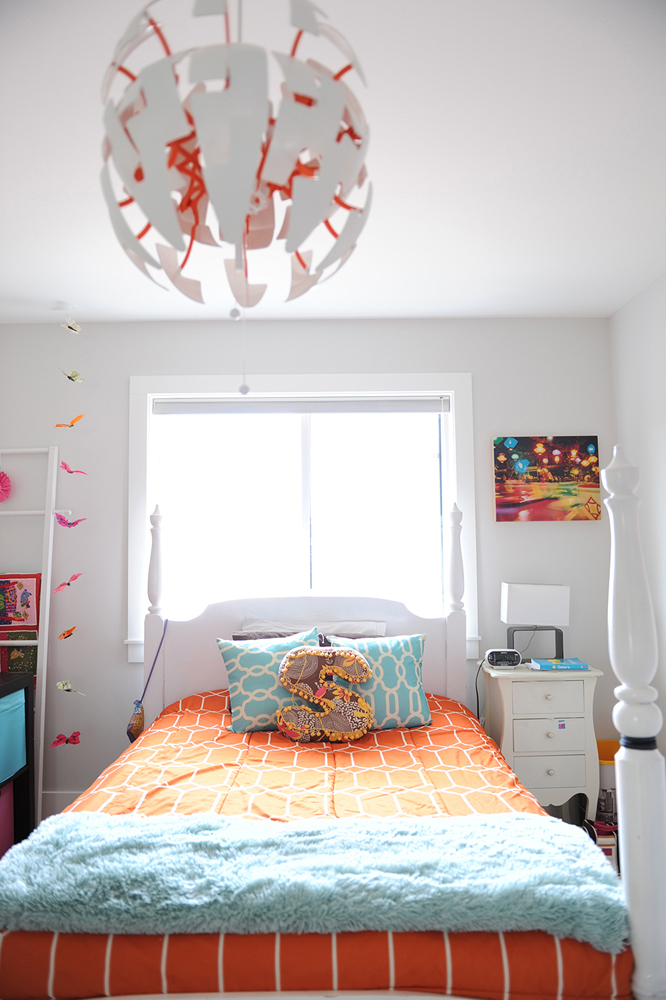 bedroom with orange bedspread ans S pillow on bed