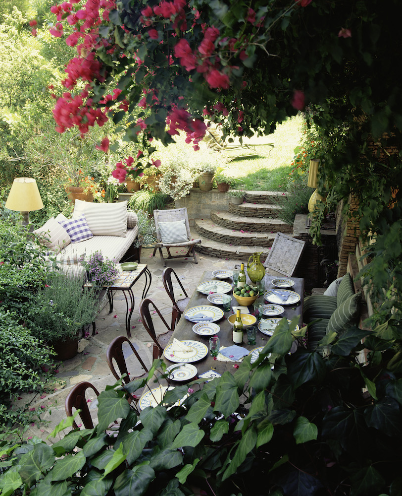 outdoor dining space surrounded by flowers and green plants