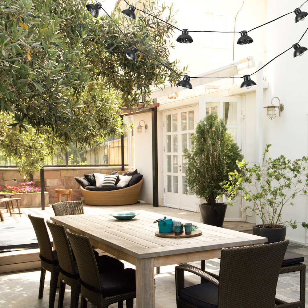 Black pendant string lights over outdoor dining table
