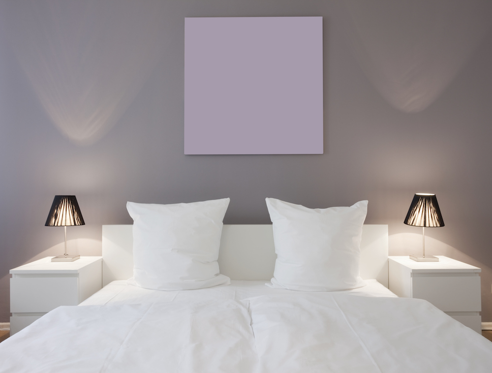 purple bedroom with white bed with white night stands and lights
