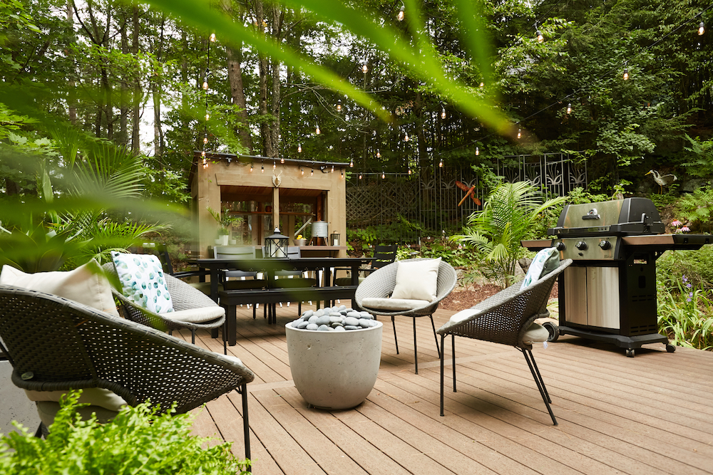 A renovated backyard paradise with a wood deck, lounge chairs, BBQ and pergola