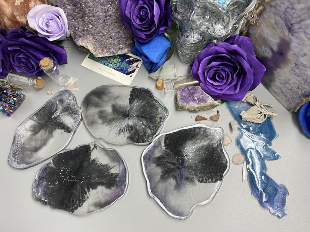 Gray agate coasters against a background of blue flowers and crystal rocks