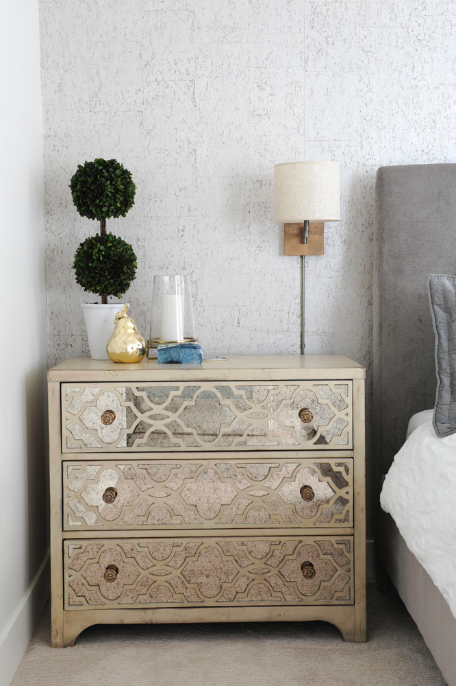 three drawer bedside chest with topiary on top.