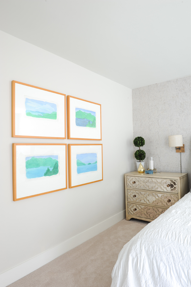 four blue and green framed pictures in bedroom