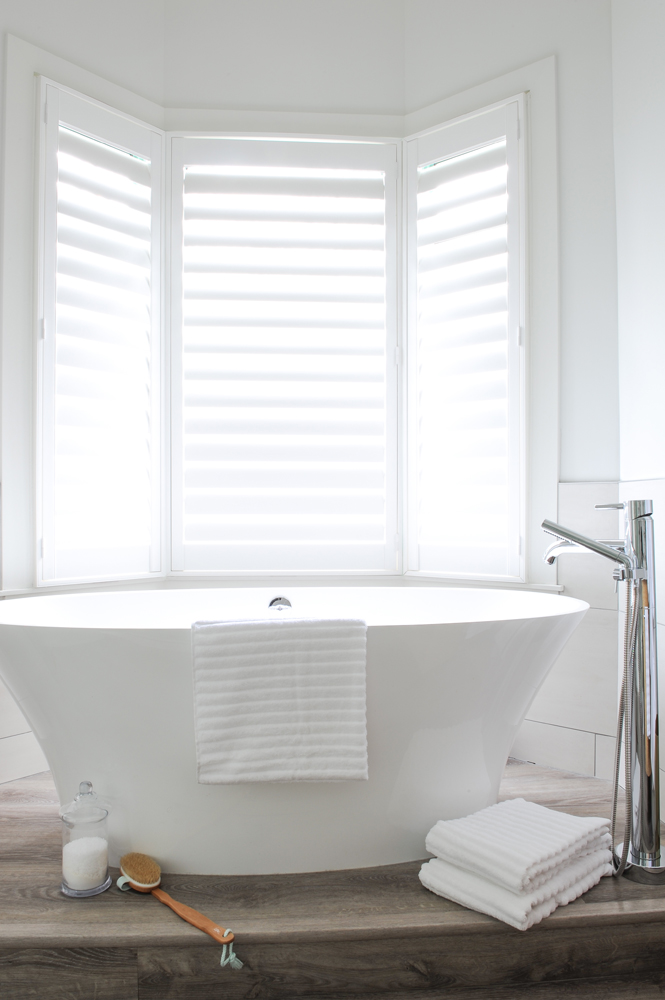 white vessel tub in front of white shutters