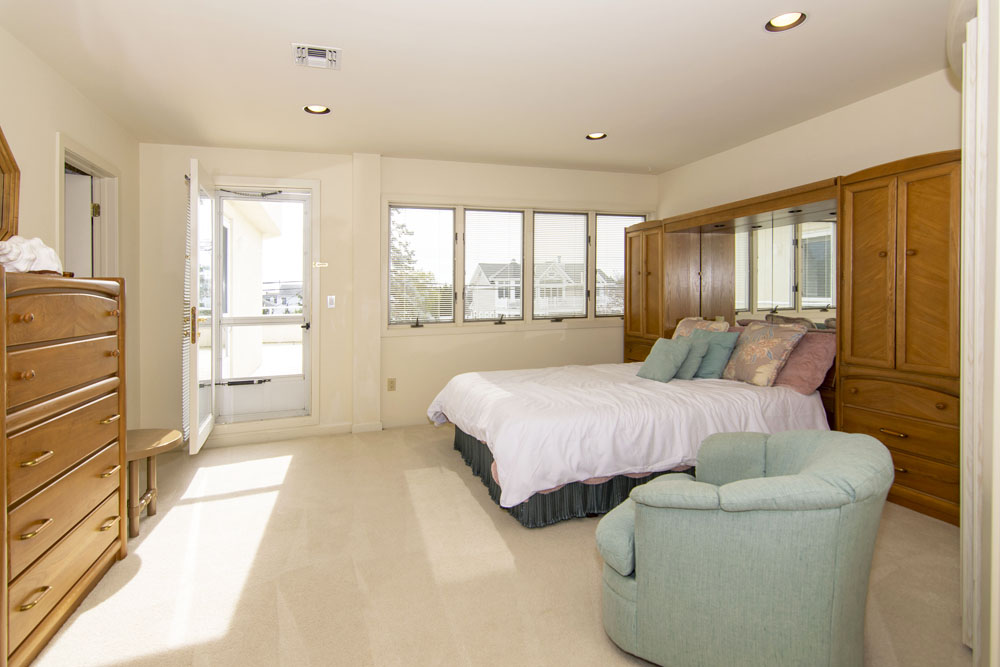 Another guest bedroom with carpeting, blonde hardwood furniture and views of the Jersey Shore waterfront