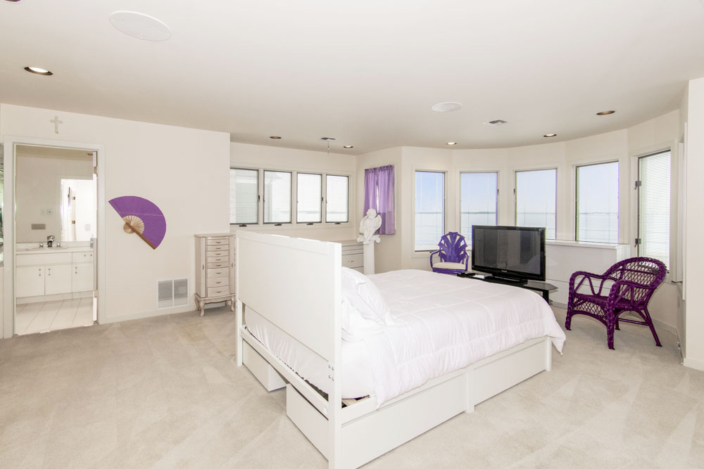 The master bedroom with a white and purple colour palette