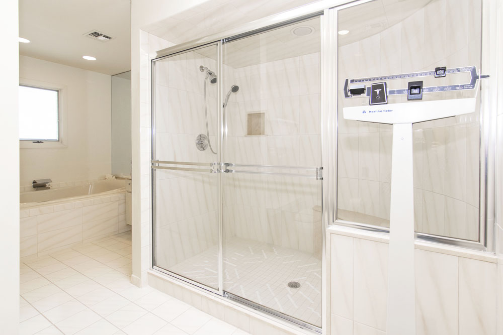 An all-white master bathroom with a large shower and separate bathtub