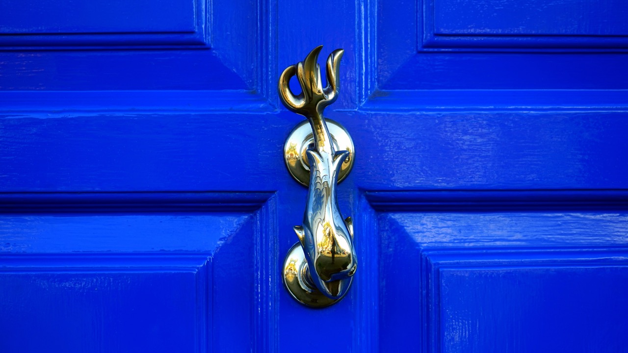A statement knocker and a bright blue door.