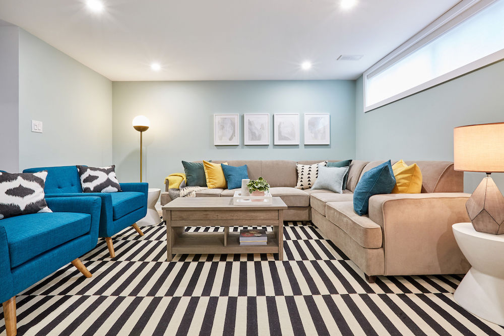 bright family room with large sectional topped with groups of three pillows