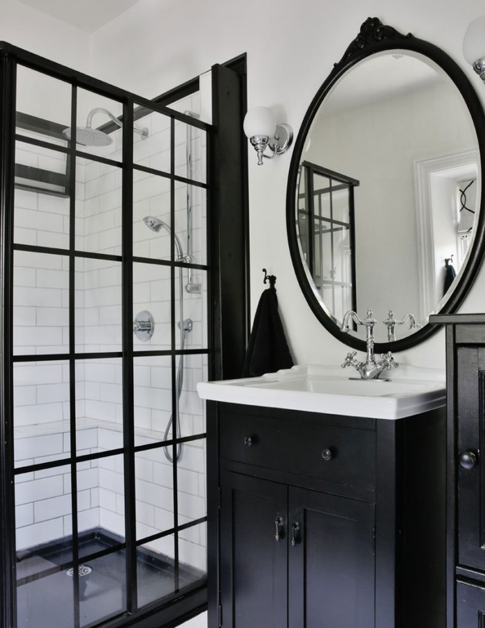 A bathroom in a black-and-white colour palette with a vinyl floor and standing matte black shower stall