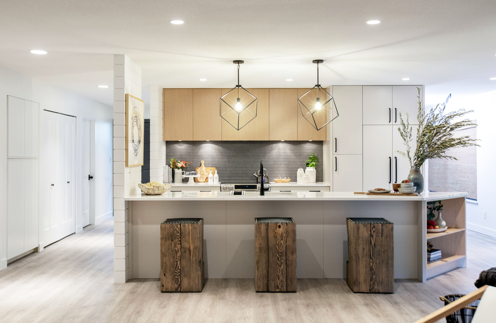 Square-shaped geometric lights above a renovated kitchen island with wood stools