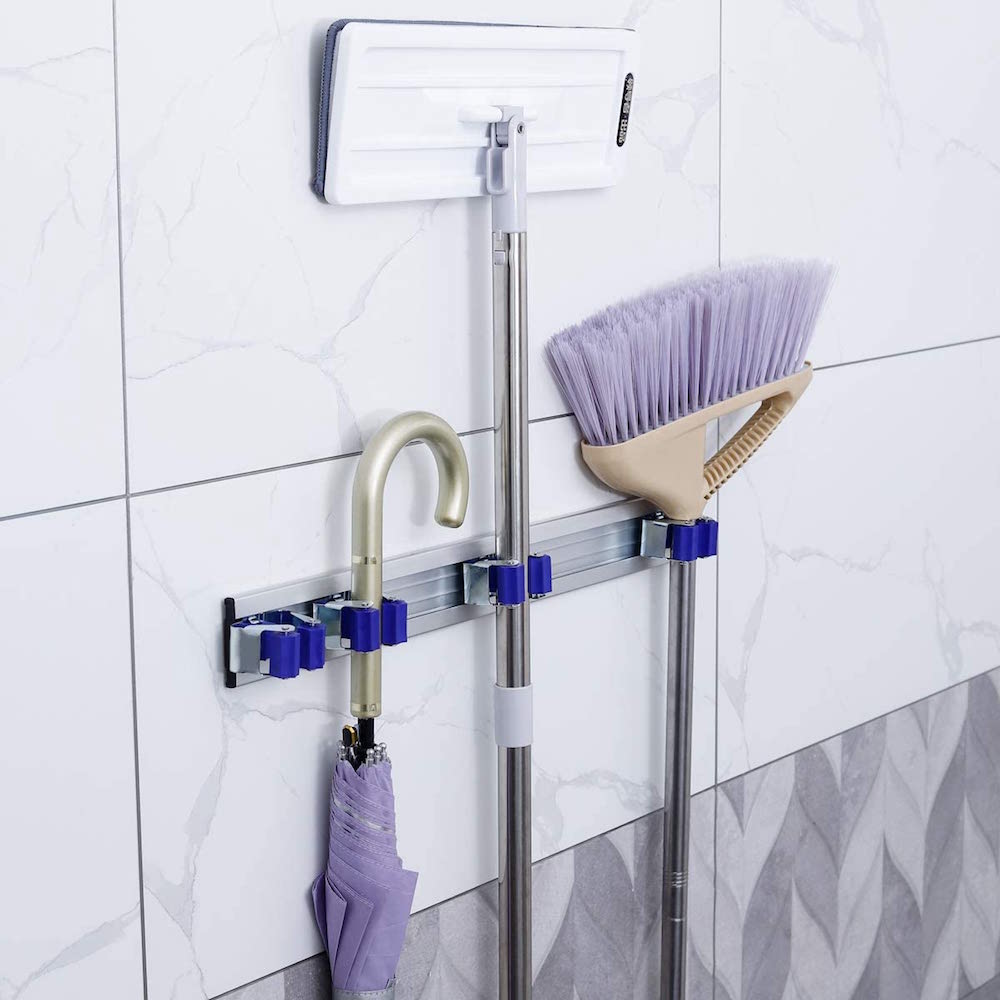 brooms and purple umbrella on wall-mounted rack