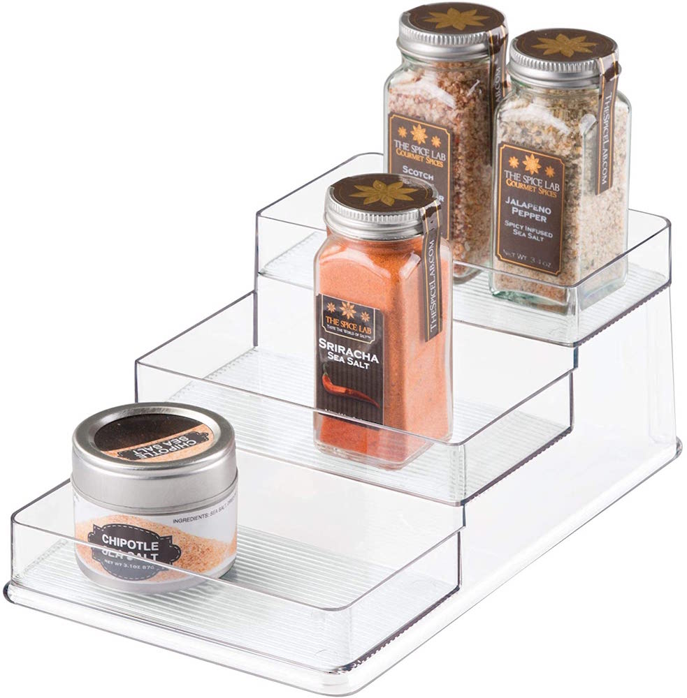 clear tiered spice rack with bottles of spices