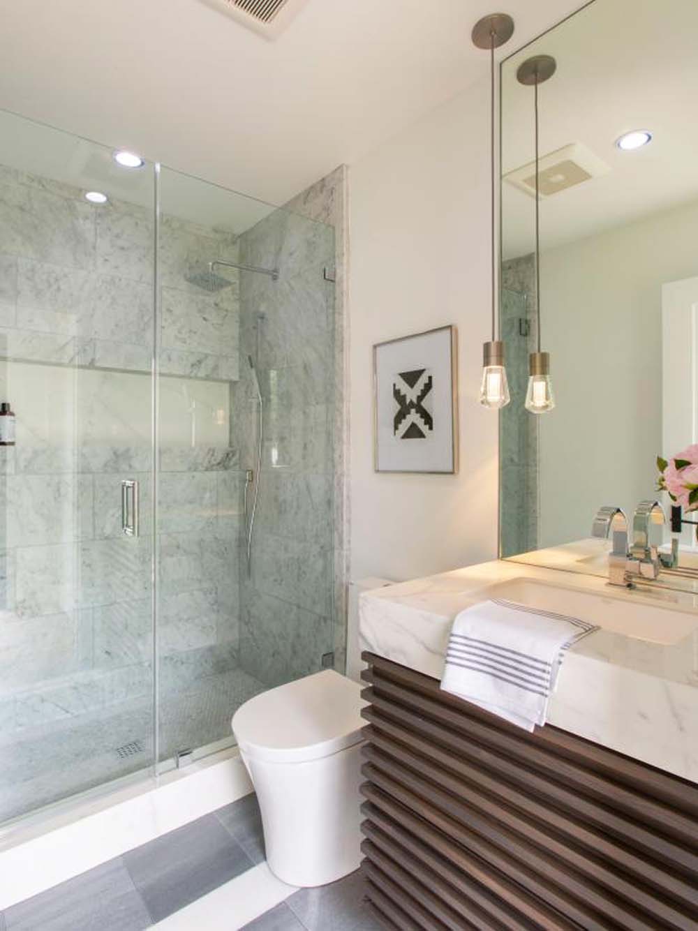 A tiny renovated monochromatic bathroom with floating vanity, chunky countertop and spa-worthy shower tiles