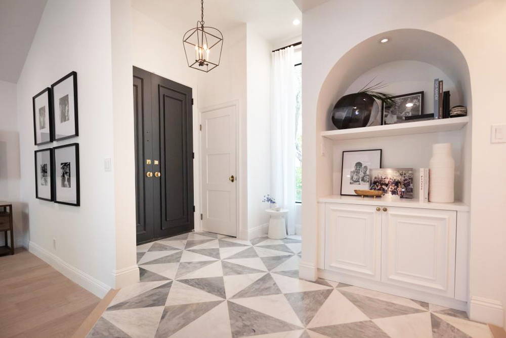 A renovated condo entryway with arched ceiling and built-in shelving