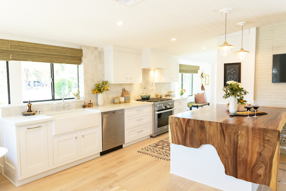 A mid-century modern farmhouse aesthetic in a renovated kitchen, including a live-edge waterfall island