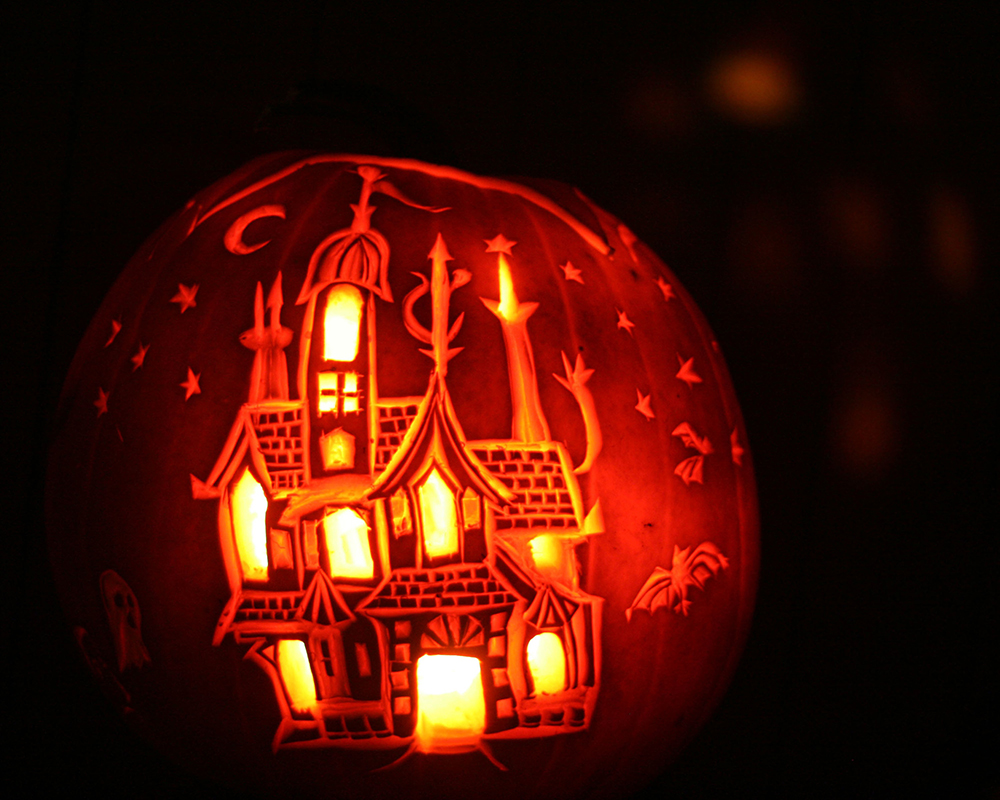 Carved pumpkin with haunted house