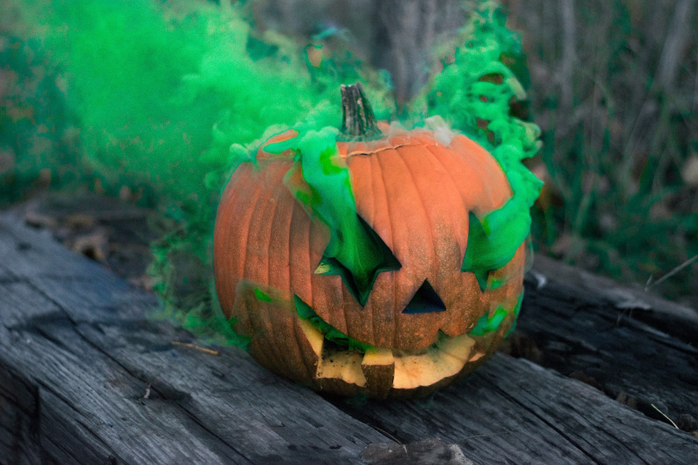 Jack-'o-lantern on picnic table with green smoke pouring out
