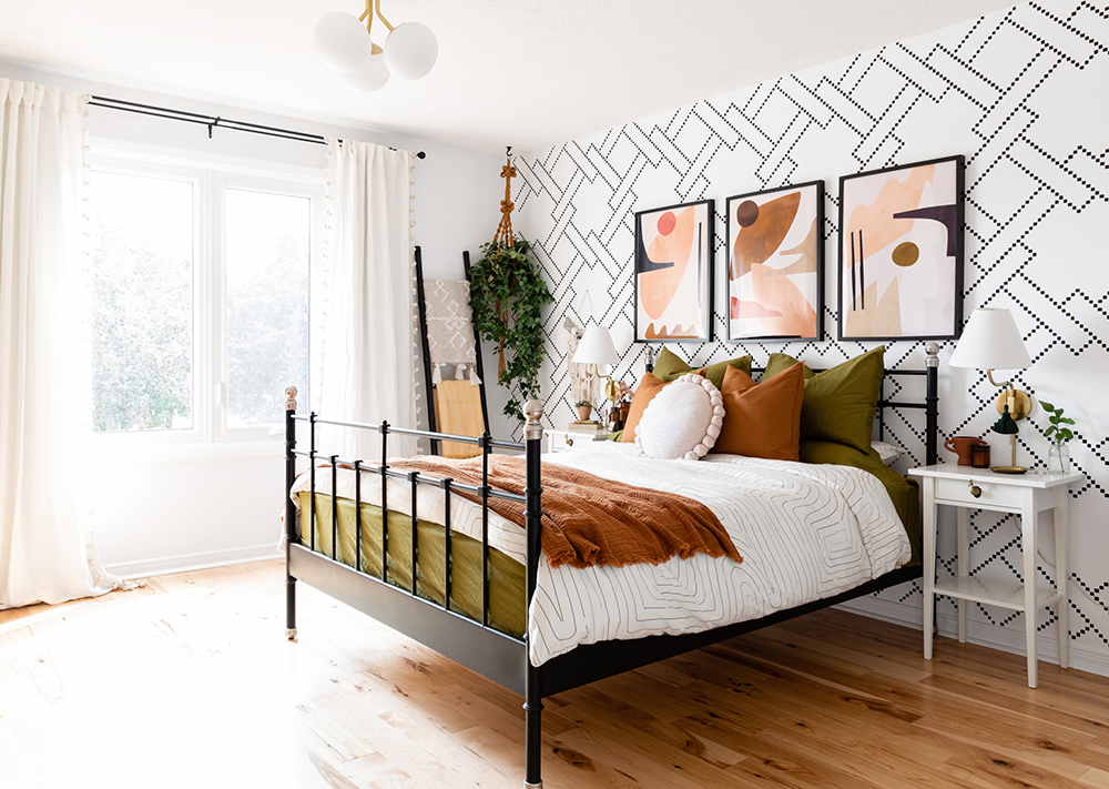 modern boho bedroom with patterned wall and wall-mounted light sconces
