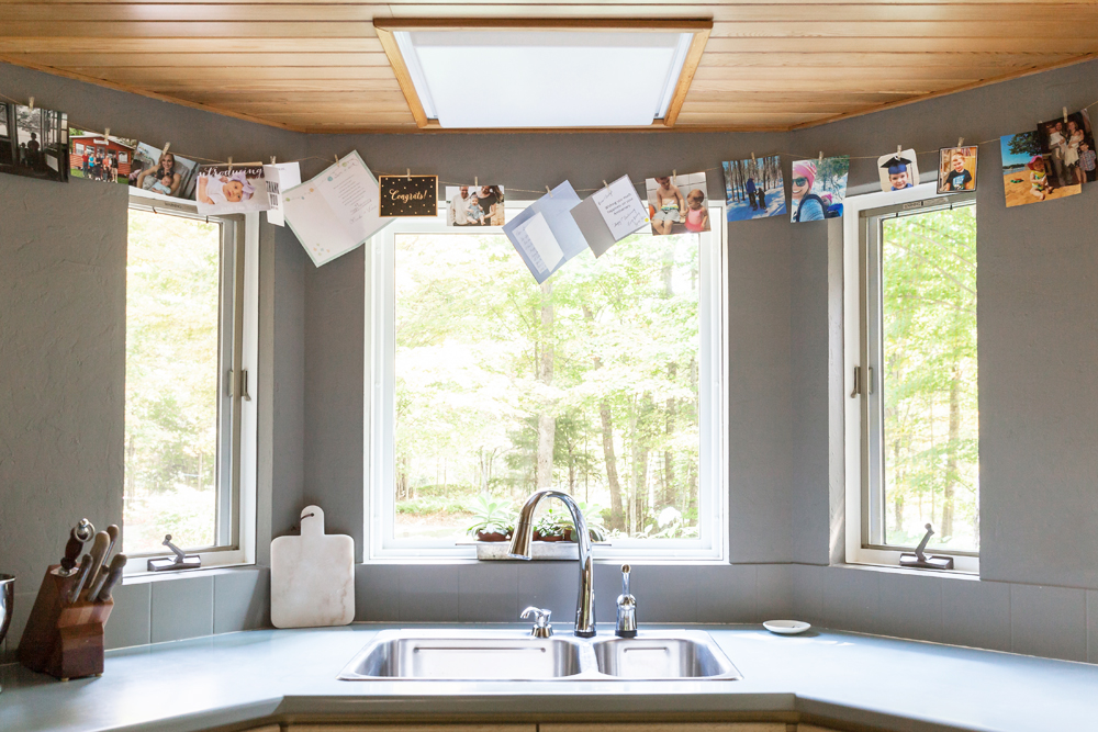 A string of personal photos and letters hanging above the kitchen sink for a personal touch
