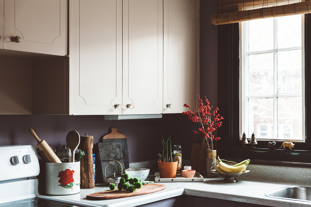A well-organized kitchen counter featuring rustic earthenware and houseplants