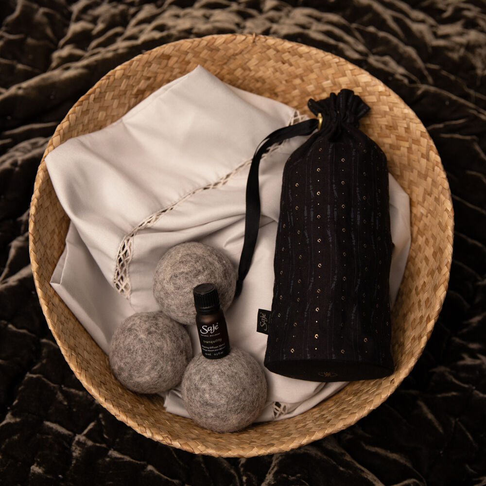 A basket filled with reusable dryer balls and essential oils