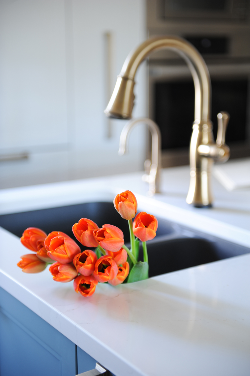 orange tulips in kitchen sink