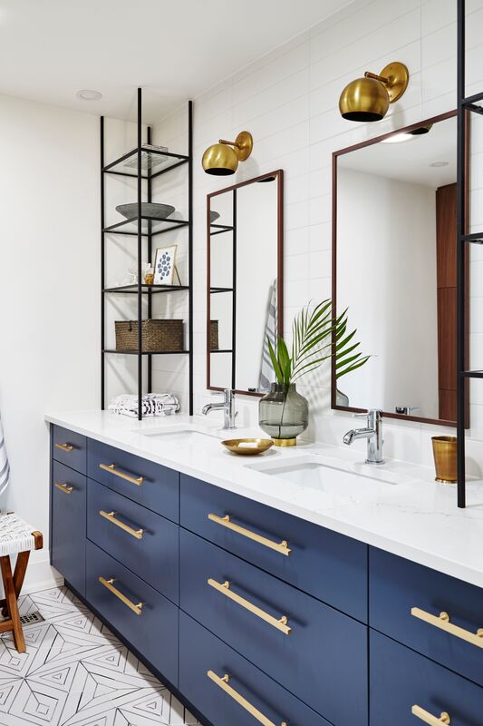 double sink vanity, blue drawers, brass pulls, palm leaf between tow wood framed long rectangular mirrors