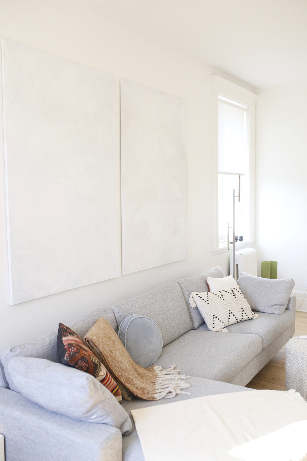 grey sectional, two pieces of white wall art