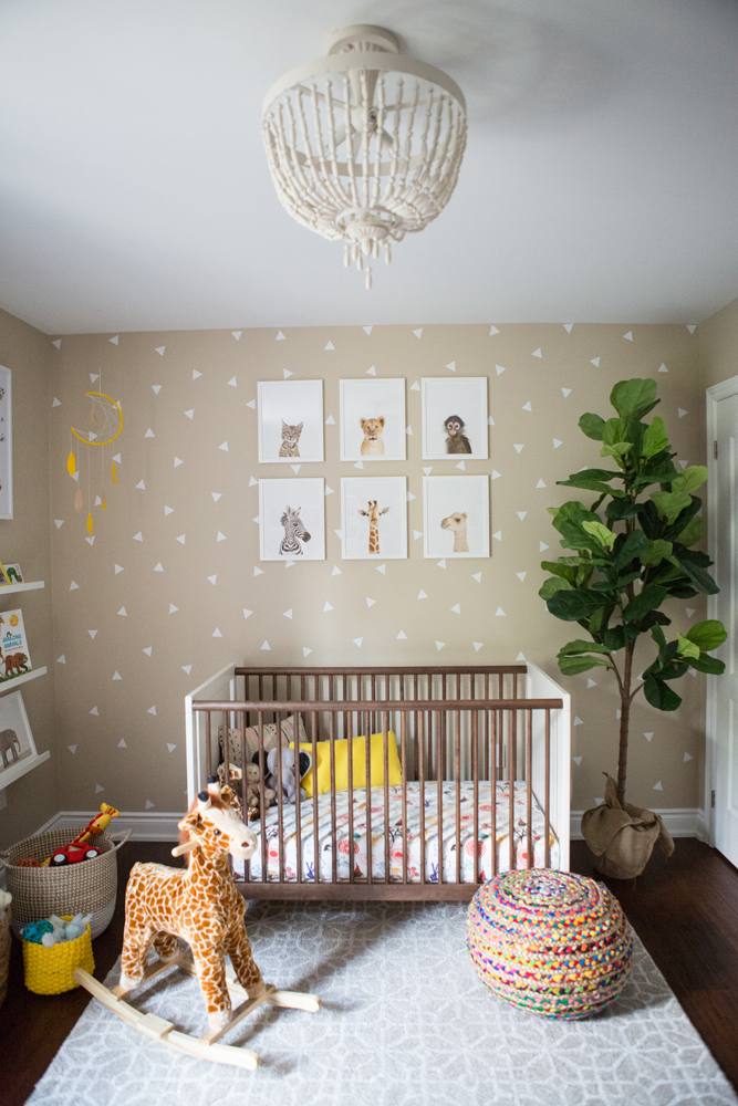 crib in nursery with tan and white triangle wallpaper