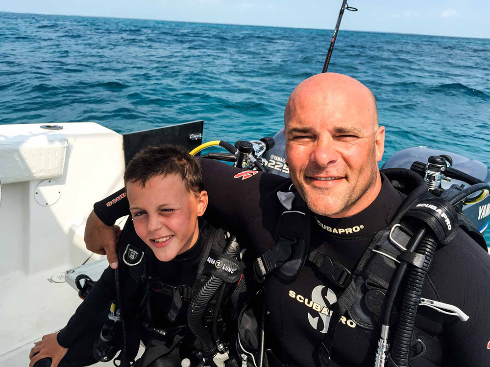 Bryan Baeumler posing with his son in scuba diving gear